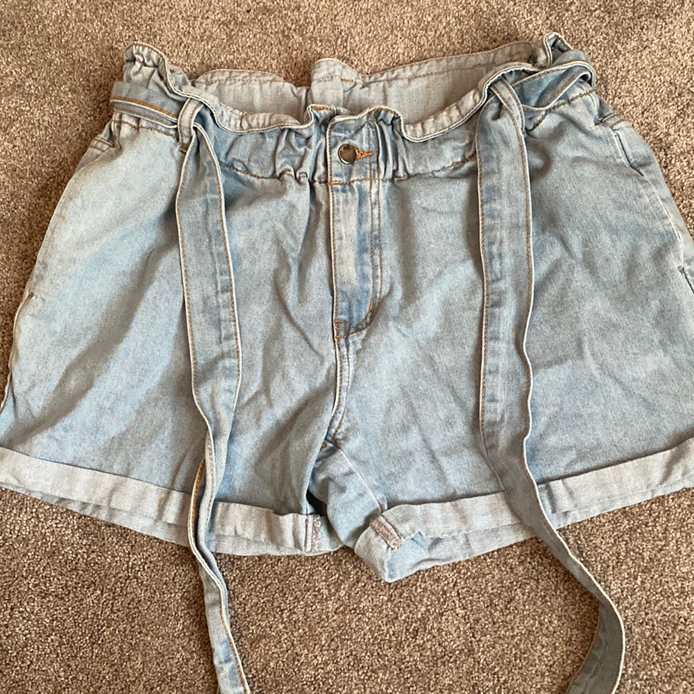 Size large light wash jeans shorts. High wasted with tie in the front.